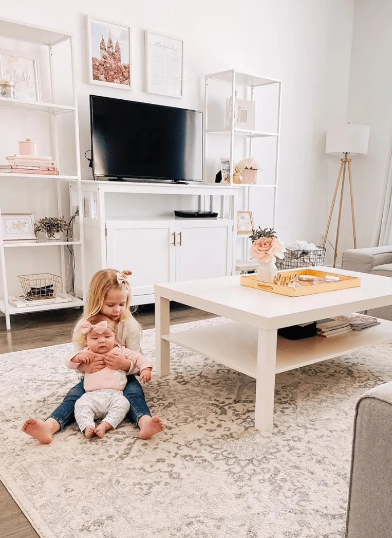 Sisters play in front of cute living room home decor.