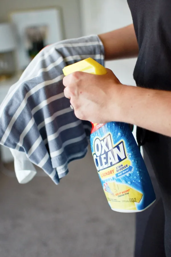 Woman sprays shirt to clean out stains.