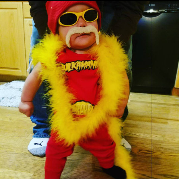 Baby boy wearing Hulk Hogan kids Halloween costume standing in front of adult.