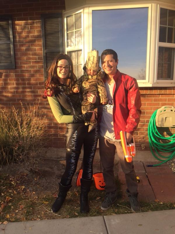 Family wearing Guardians of the Galaxy Halloween costumes smiles in front of house.