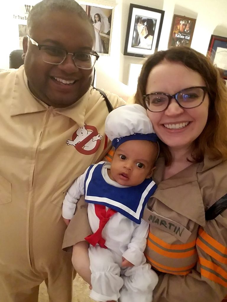 Couple with baby dressed up in Ghost Busters costumes.