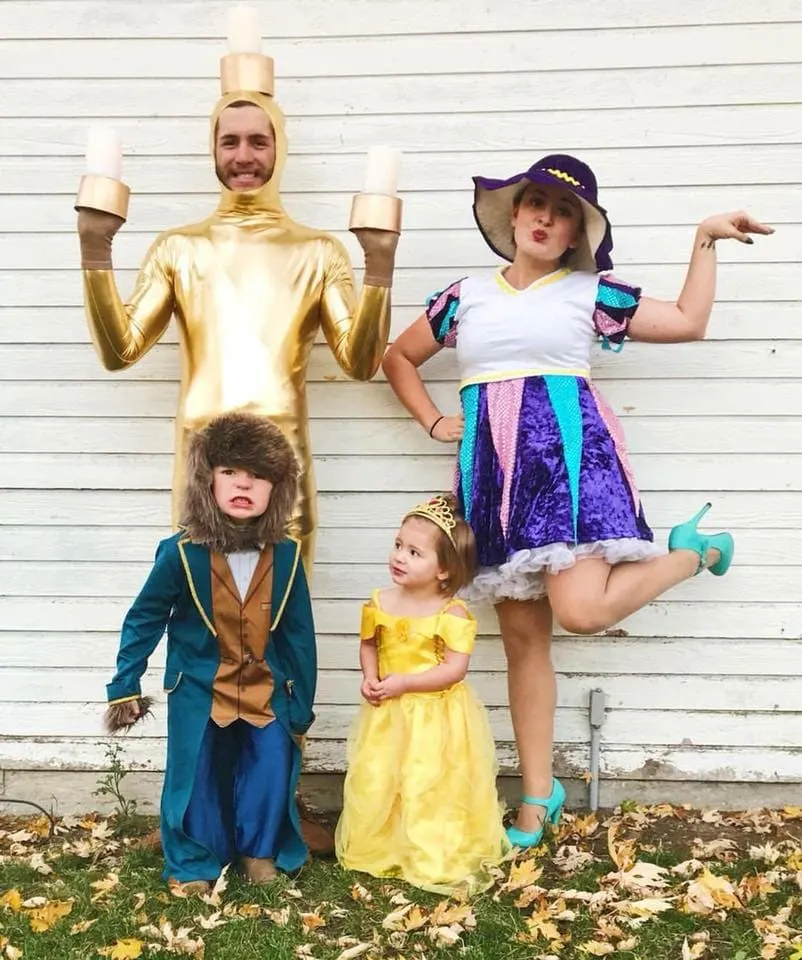 Family wearing Beauty and the Beast Halloween costumes poses in front of white wood wall.