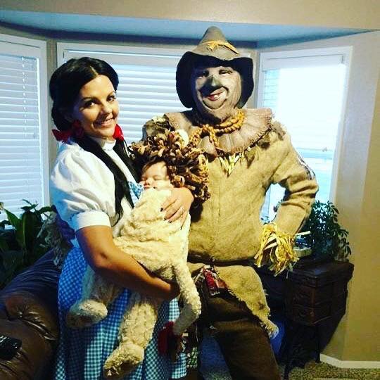 A woman dressed as Dorothy, a Man dressed as the Tin Man, and a baby dressed as the Lion from the Wizard of Oz.
