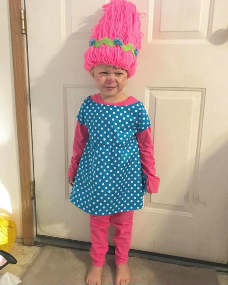 Little girl squints her eyes while wearing DIY Princess Poppy Halloween costume.