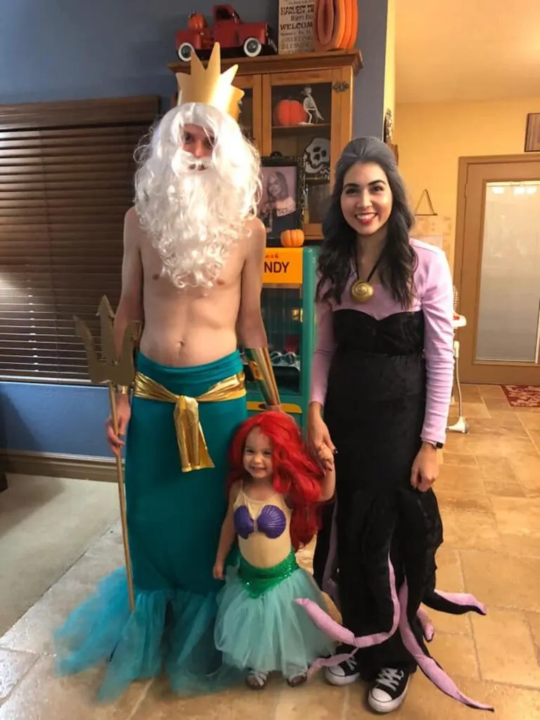 Family of 3 wearing Little Mermaid costumes.