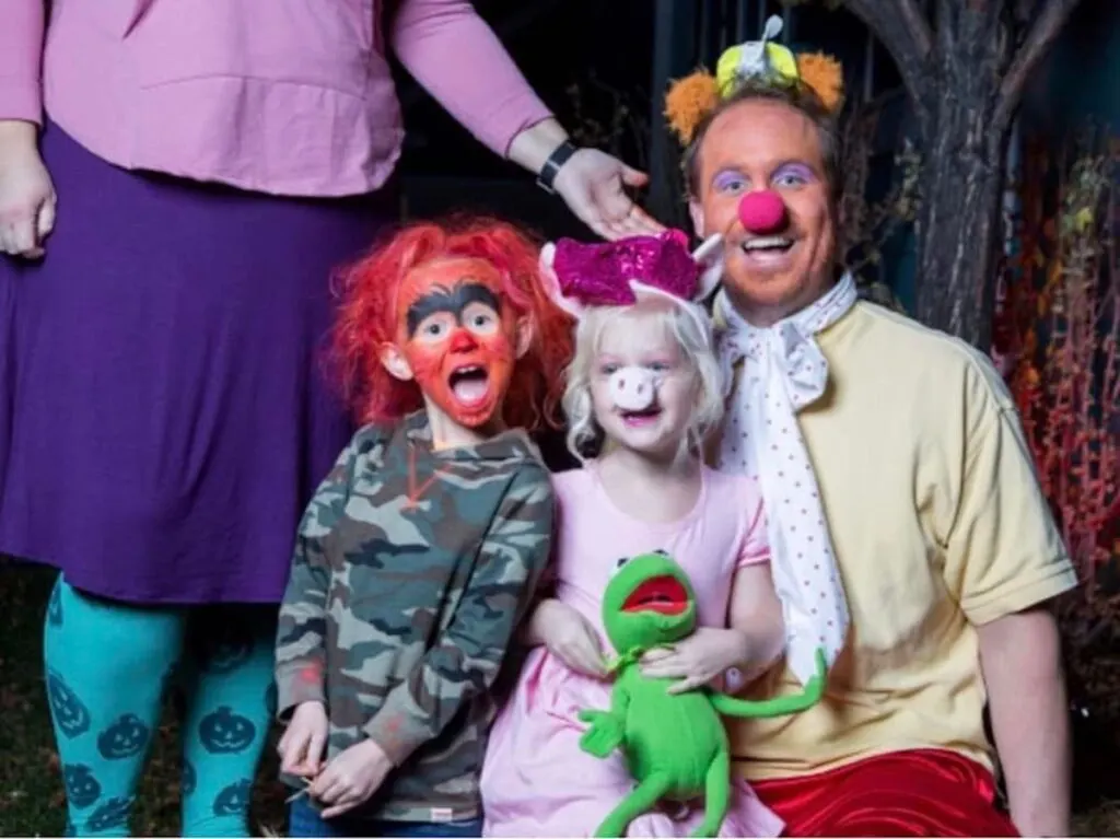 Man and children dressed up in Muppet Baby costumes.
