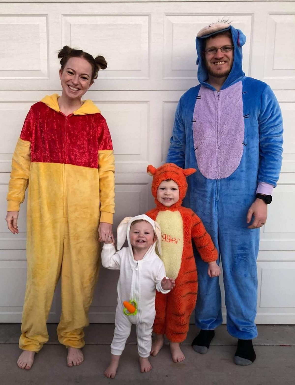 Family of 4 wearing Winnine the Pooh costumes.
