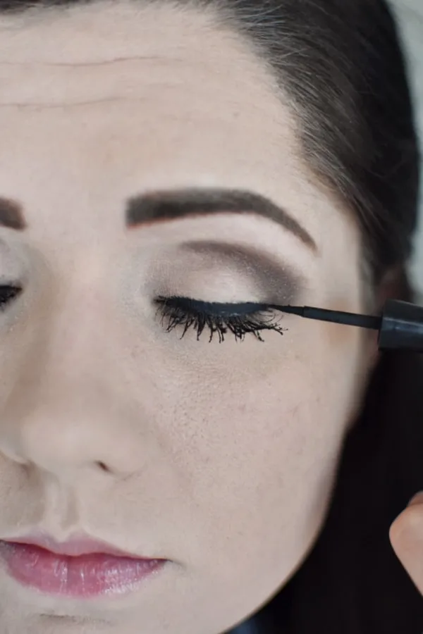 Woman applying eye liner during an easy smokey eye tutorial 