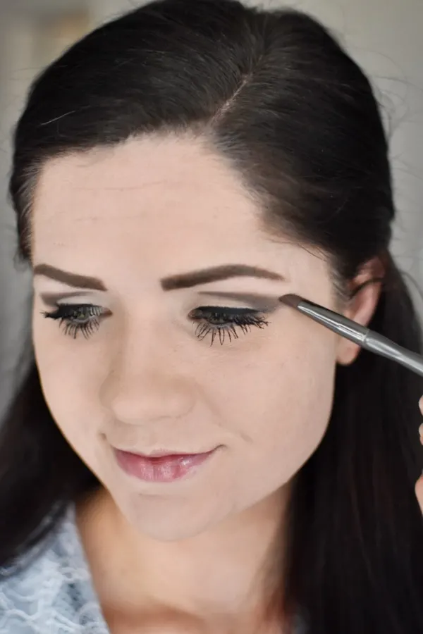 Woman shows an easy smokey eye tutorial using only drugstore makeup! I