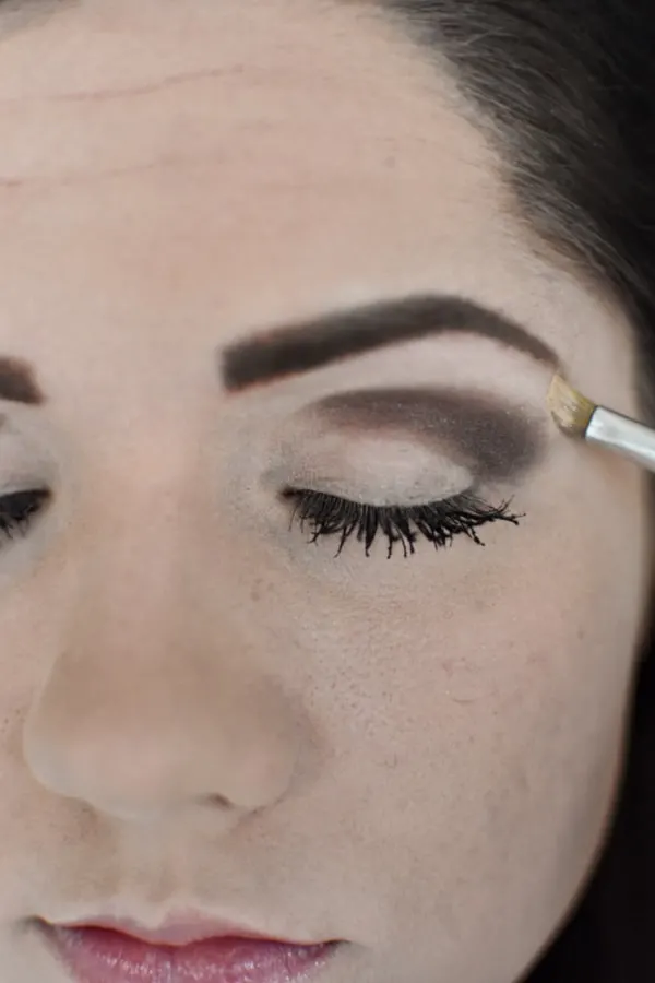 Woman applying light eye shadow during an easy smokey eye tutorial 