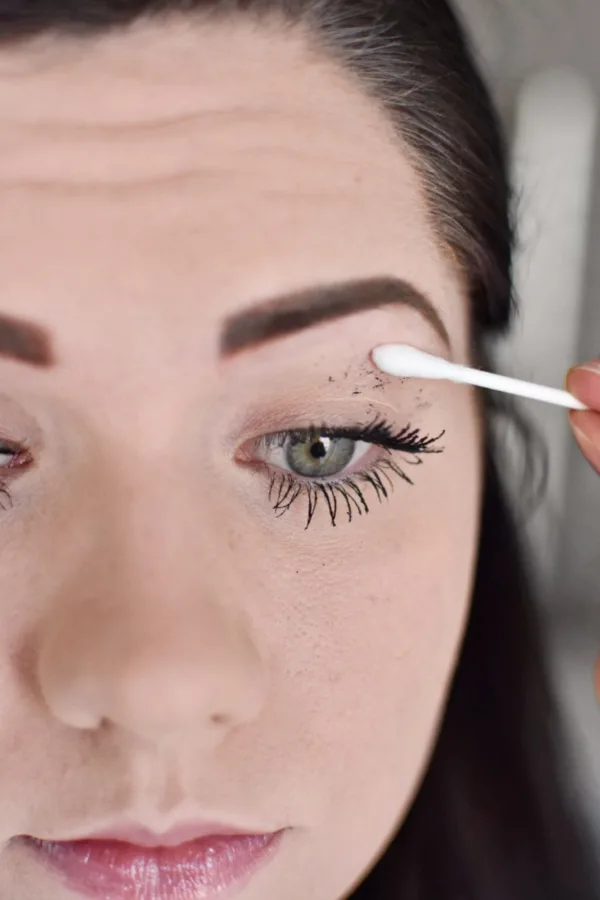 Woman cleaning mascara mistakes during an easy smokey eye tutorial 
