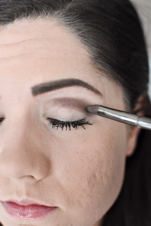 Woman applying crease eye shadow during an easy smokey eye tutorial 
