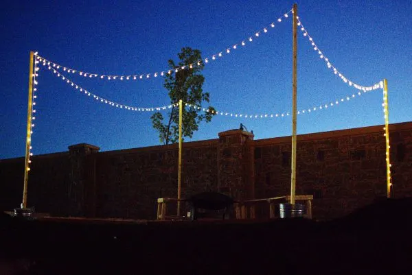 Amazon backyard lights strung on DIY light poles.