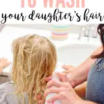 Pinterest graphic with text that reads "The Best Way to Wash Your Daughter's Hair" and a mom washing her daughter's hair outside of the tub.