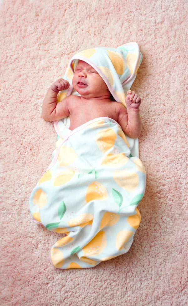 Baby snuggled in towel after bath routine.