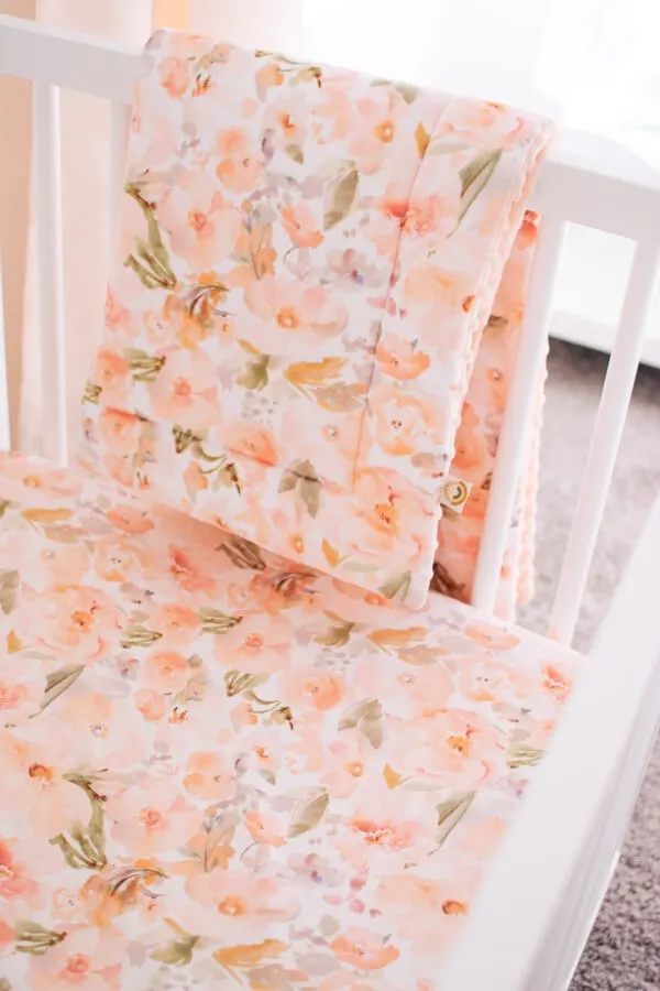 Peach and floral baby girl crib bedding.