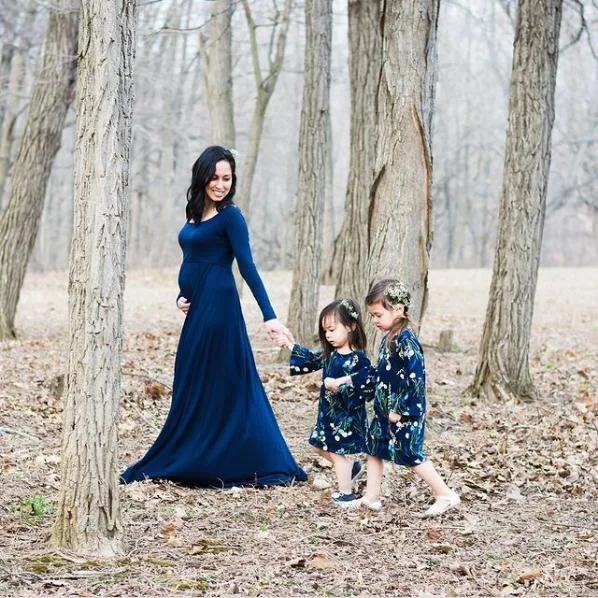 Mom walks through the woods with her two daughters.