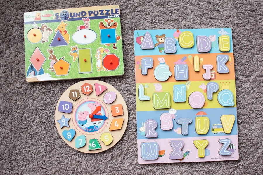 Three toddler puzzles on the floor.