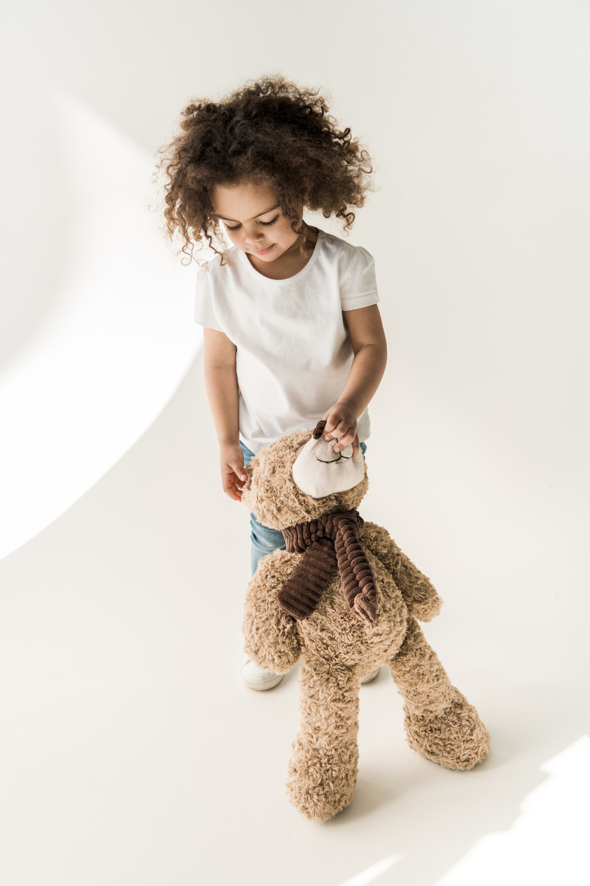 Toddler girl holds a teddy bear.