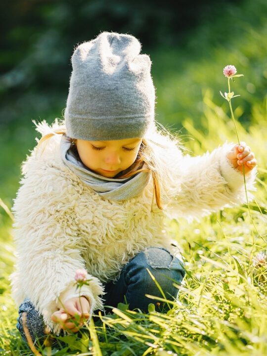 Little girl picks flowers in a meadow.