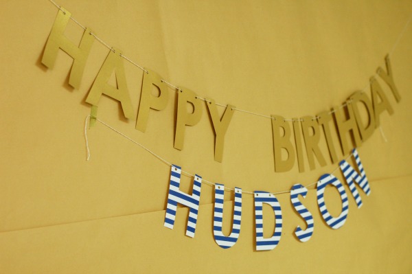 Gold and striped birthday banner on craft paper background.