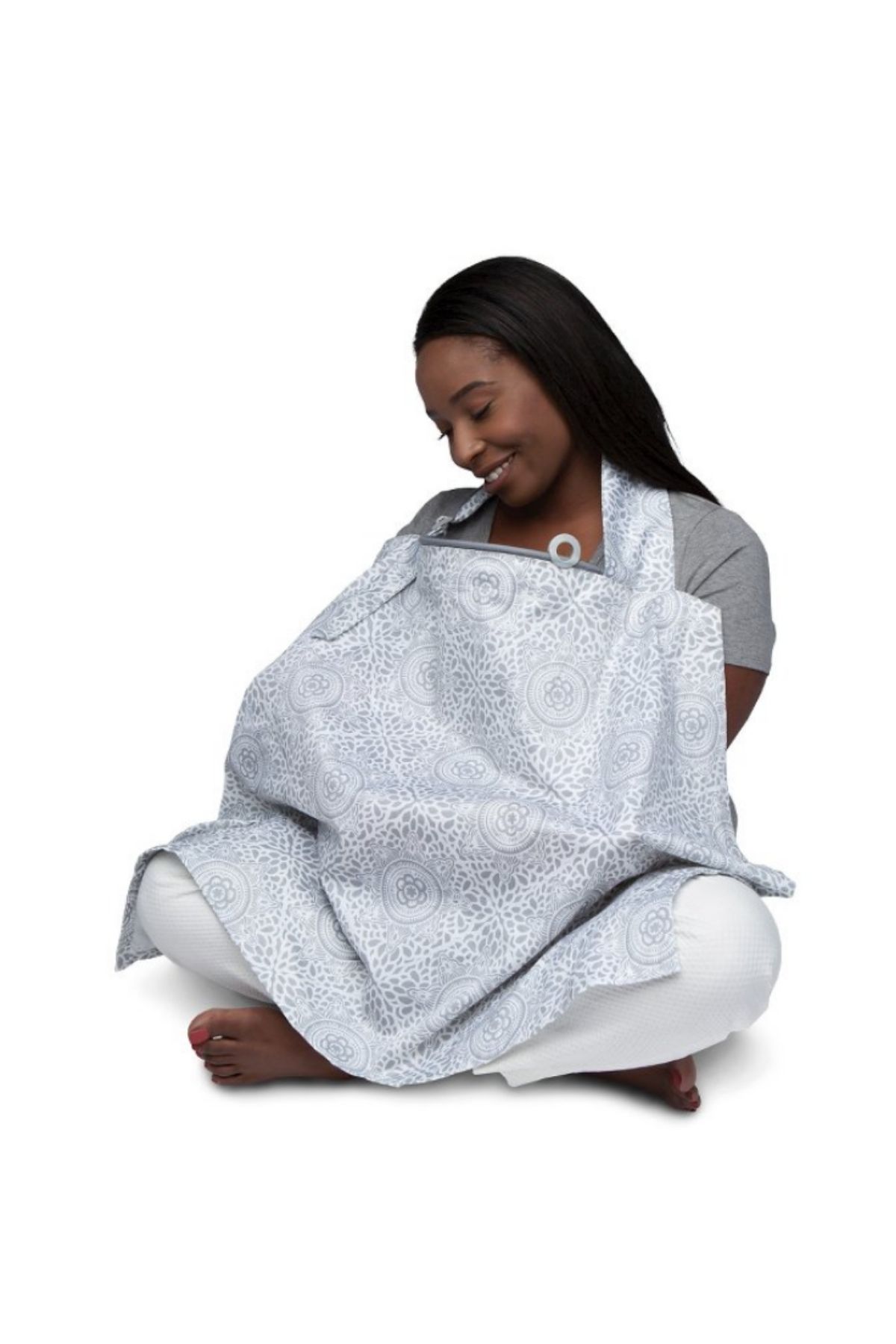 Woman breastfeeds baby wearing nursing cover.