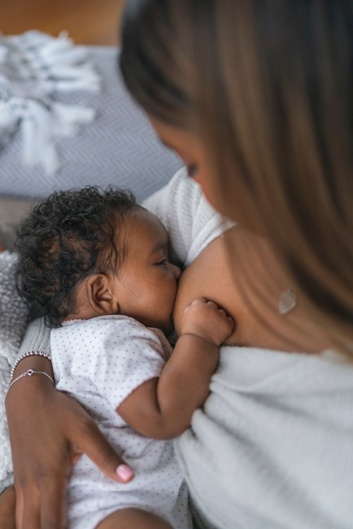 New mom breastfeeding baby girl on regular schedule to optimally refill breast milk supply.