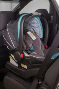 Rear facing gray, blue, and black child's car seat in a car.