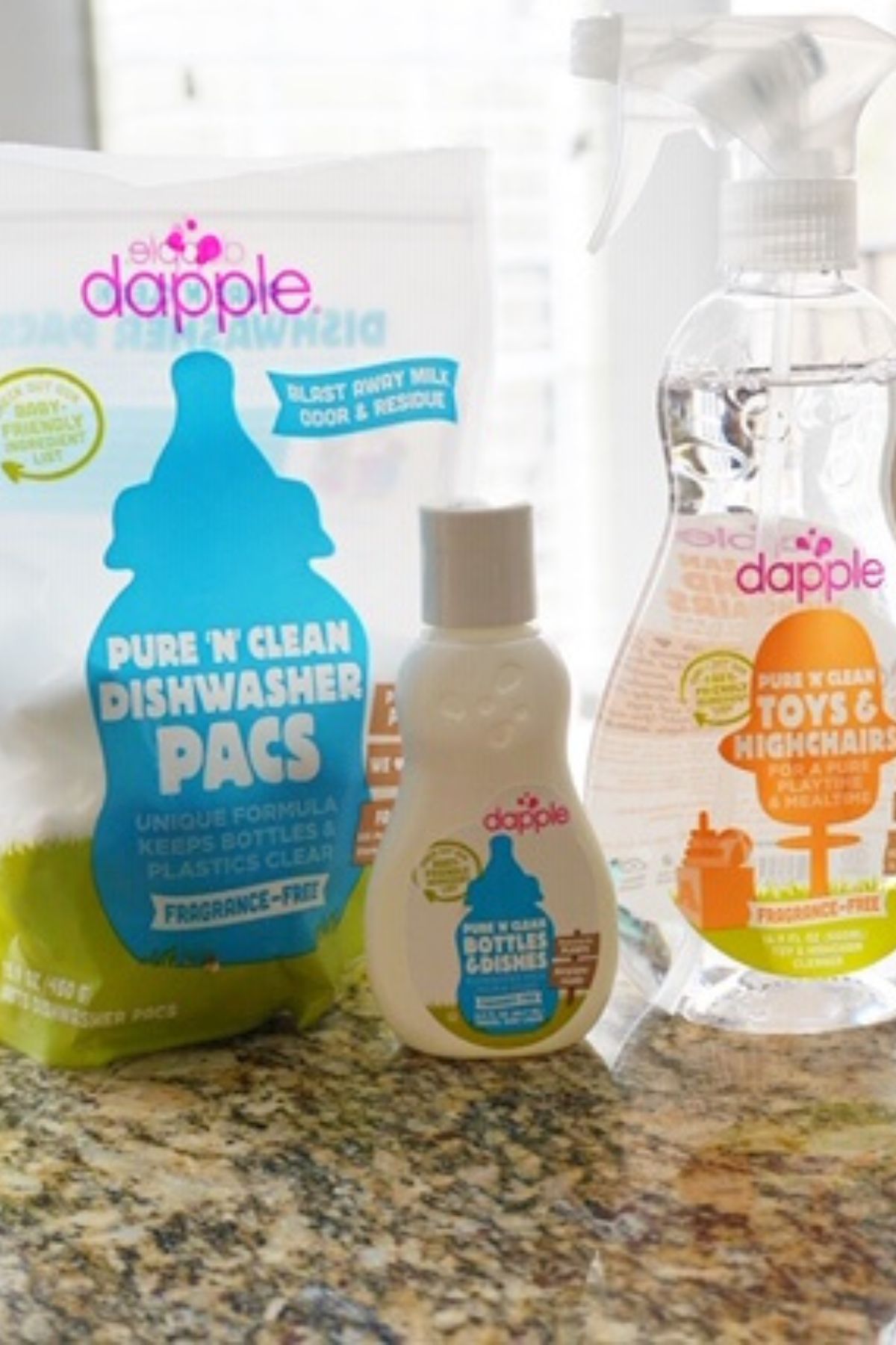 Assortment of baby bottle dishwasher detergents and soaps on a kitchen counter.