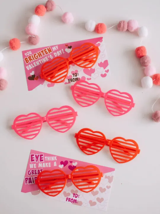 Heart-shaped pink and red sunglasses with Valentine's Day cards.