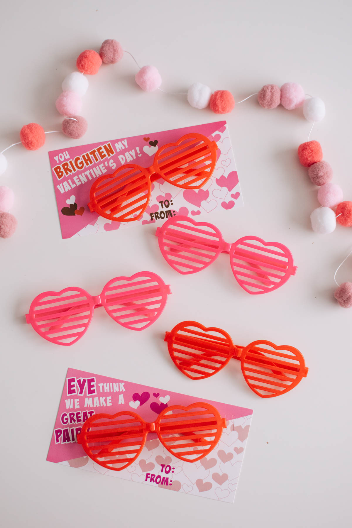 Heart-shaped pink and red sunglasses with Valentine's Day cards.