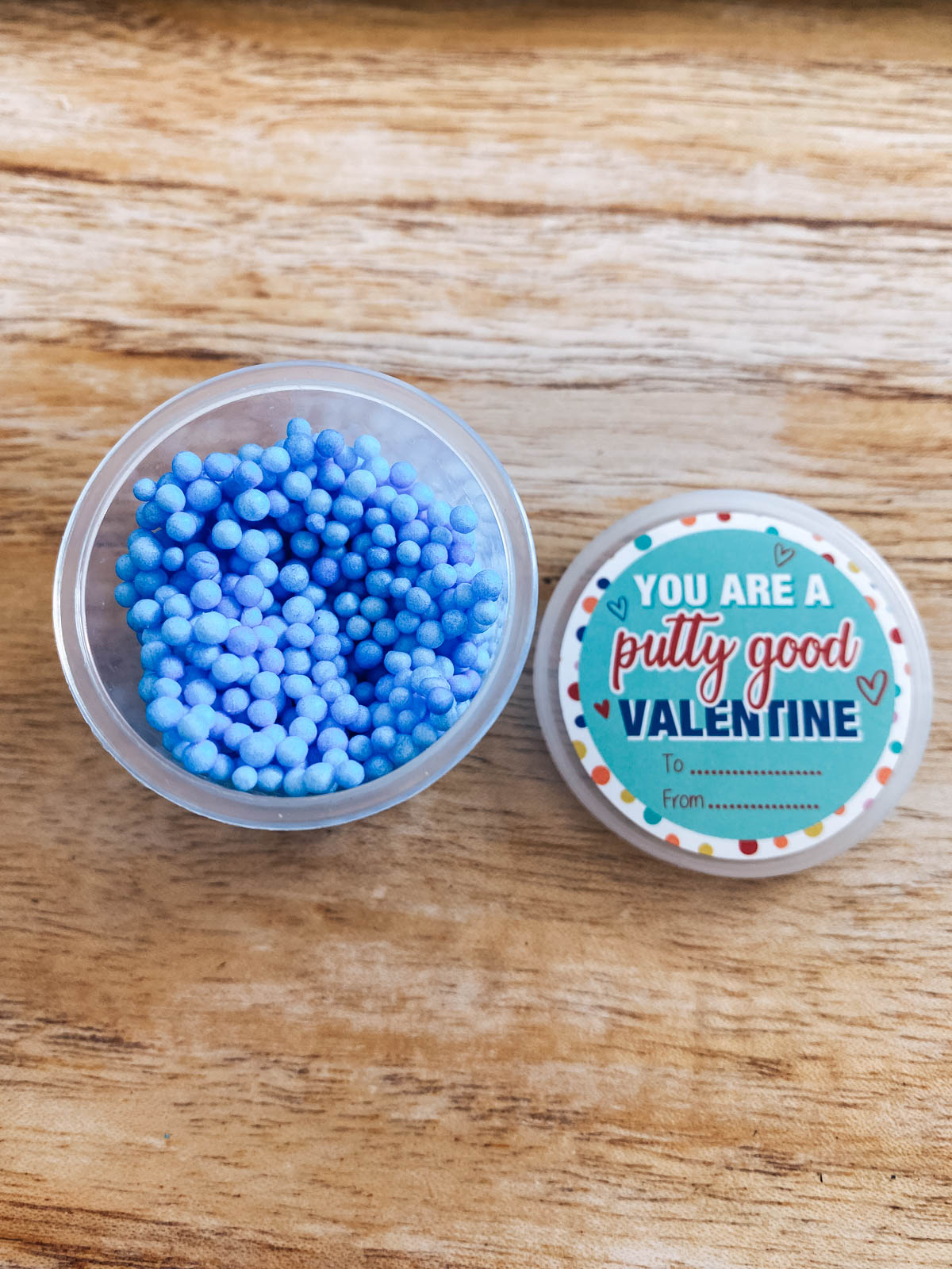 Putty beads in a mini plastic container with witty saying for Valentine's Day.