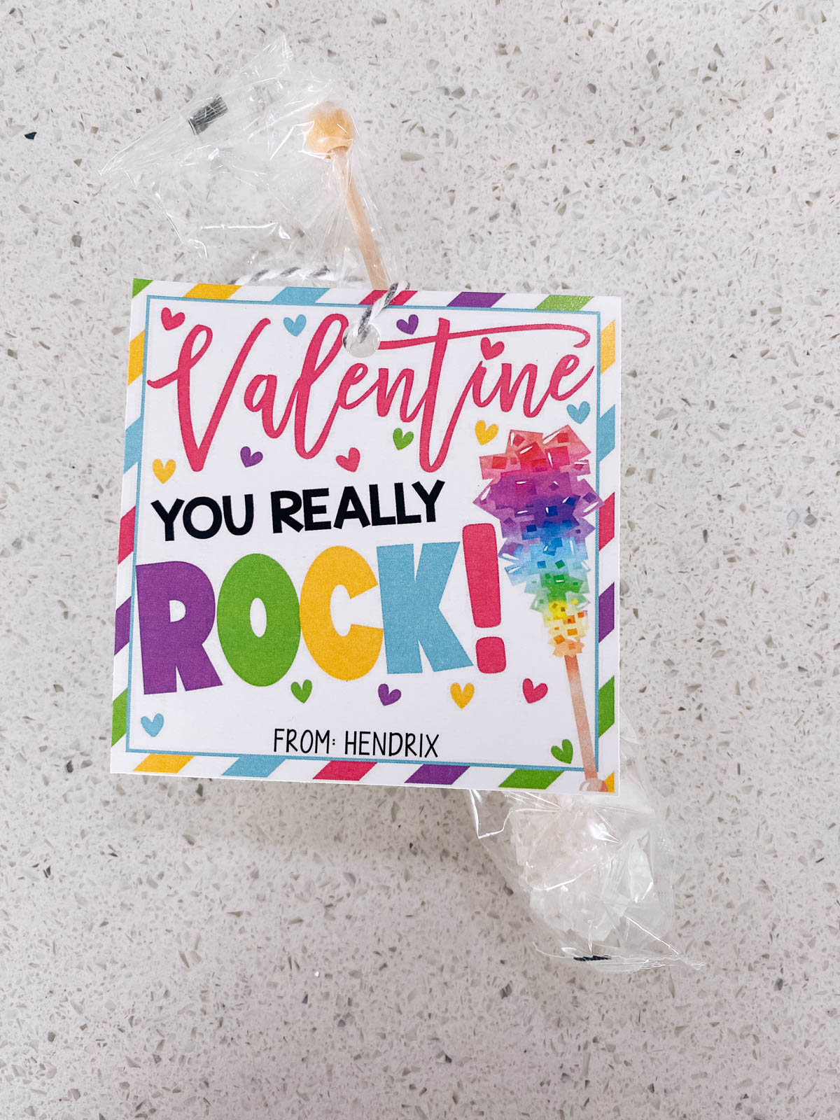 Rock candy in a plastic bag with a Valentine gift tag on kitchen counter.