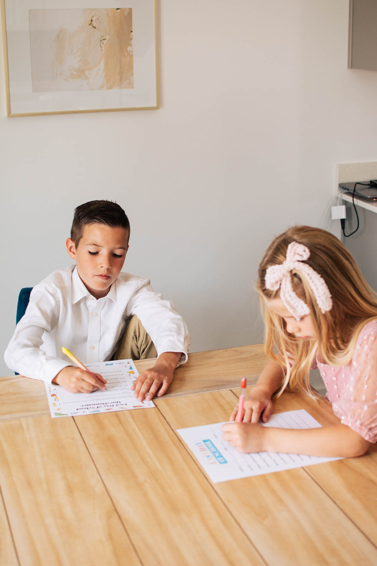 Boy and girl sit at kitchen table filling out last day of school questionnaire.