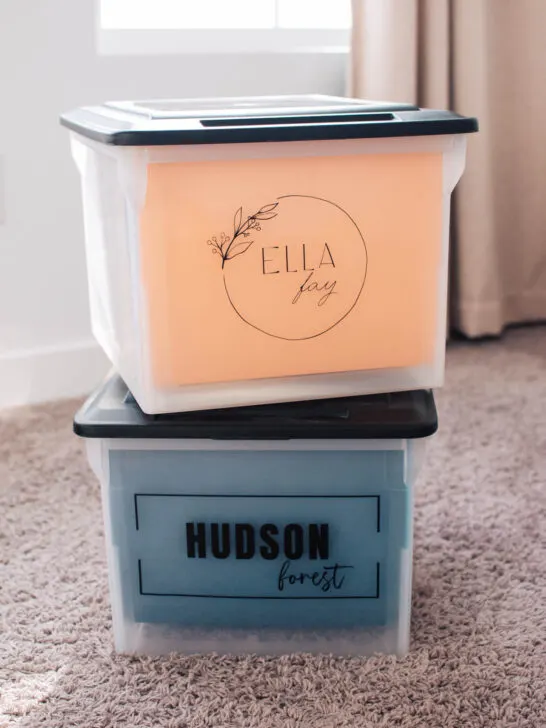 Two school memory boxes personalized with name labels stacked on each other in bedroom.