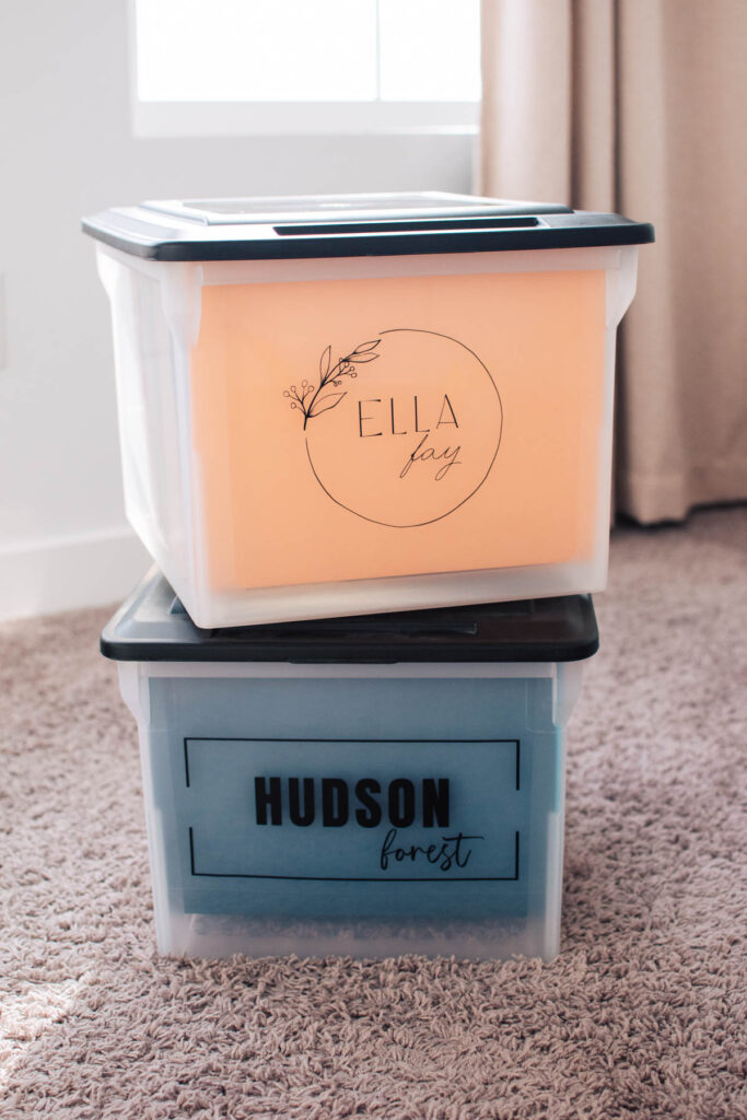 Two school memory boxes personalized with name labels stacked on each other in bedroom.