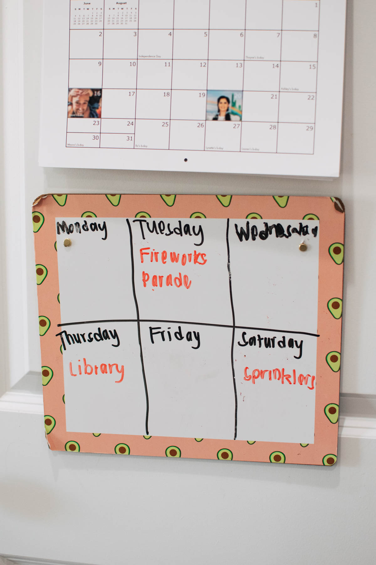White board with squares drawn and days of the week written along with summer activities in a few squares.