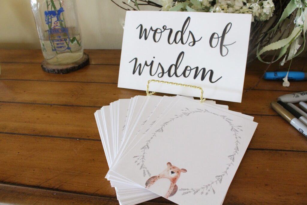 A sign that says "Words of Wisdom" and a stack of black cards with a woodland-themed border.