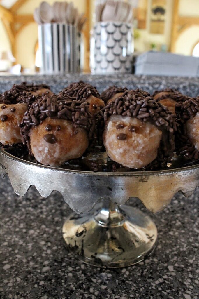 Donut hole "hedgehogs" on a silver stand on a granite countertop.