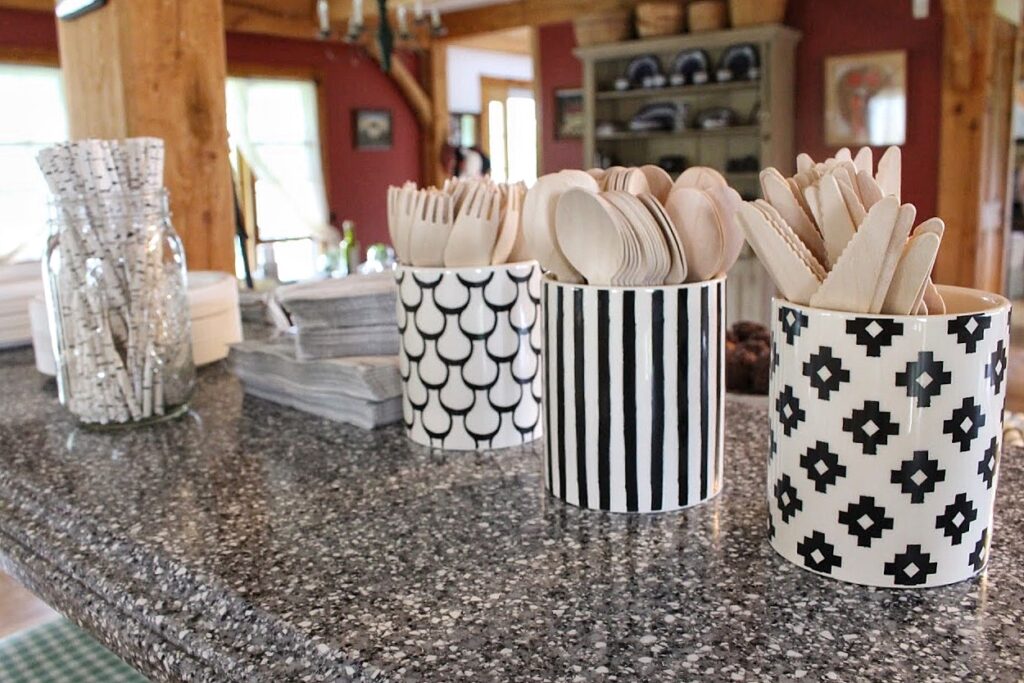 Utensil cups with different black and white designs at a baby shower party.