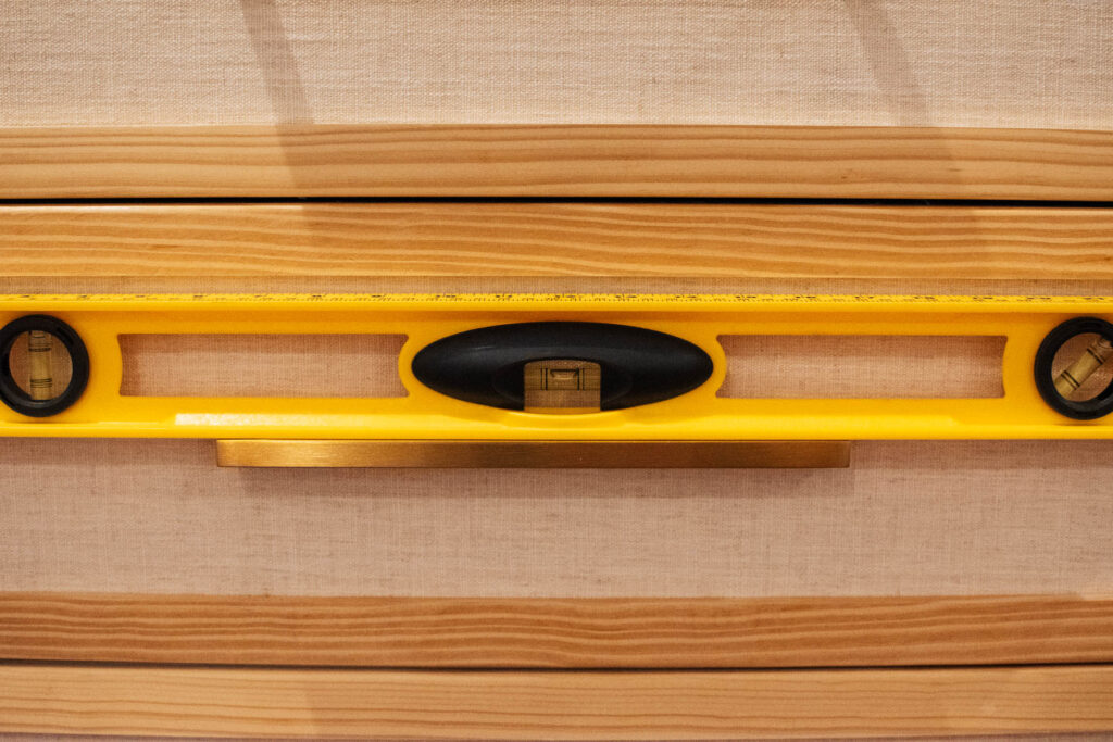 Yellow level resting on gold drawer handle.