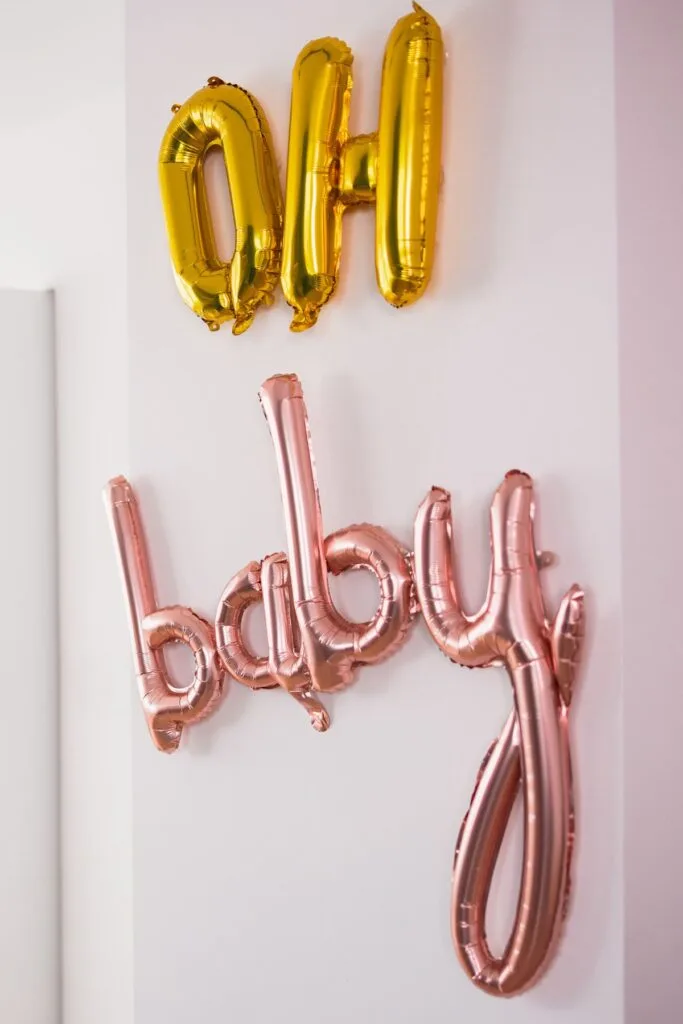 Gold and pink balloons that spell the words "oh baby".