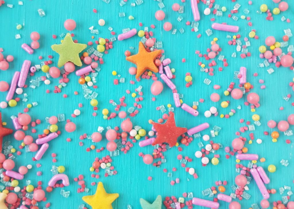 Colorful sprinkles with stars on a blue background.