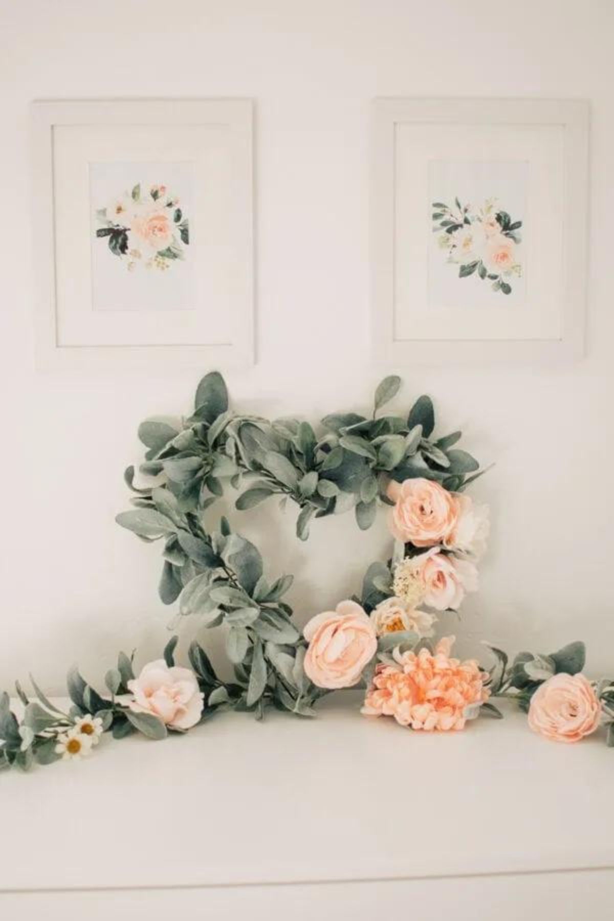 A floral heart-shaped wreath on a white side table.