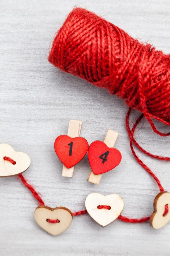 A Valentine's Day garland made from red twine and wooden heart-shaped buttons.