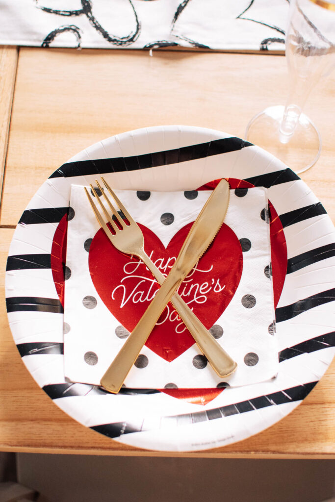 Valentine's Day place setting with napkin and gold utensils.
